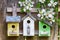 Three cute little birdhouses on wooden fence with flowers