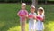 Three cute little kids eating watermelon in a summer sunny park in hot weather.