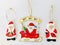 Three cute retro Santa charms on a white background.