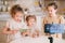 Three cute sisters playing slime on a kitchen and making video content for internet blog