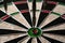 Three darts hit the dartboard. Lucky - one of the darts hits the bull& x27;s eye. The concept of winning and luck. Close