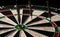 Three darts hit the dartboard. Lucky - one of the darts hits the bull& x27;s eye. The concept of winning and luck. Close