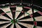 Three darts hit the dartboard. Lucky - one of the darts hits the bull& x27;s eye. The concept of winning and luck. Close