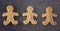 Three Decorated Gingerbread Men on a Dark Surface