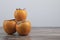 Three delicious fuyu persimmons placed on wooden table