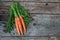 Three delicious organic rustic carrots on a wooden background