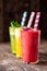 Three delicious smoothies in glass cups with two straws in each glass