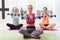 Three delighted women exercising with dumbbells in gym