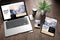 three devices on wooden desk top view travel online