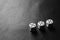 Three dice with fives on a black leather table in corner. Bw photo