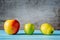 Three different apples on wooden table