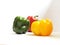 Three different and contrasting colors of green, red and yellow from fresh bell peppers on a white background with their lighting.