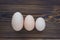 Three different eggs laying on the wooden background