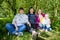 Three different funny women and one small seriously girl in the park full of apple blossom trees in a spring day. Aunts and niece