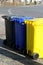 Three different multicolored dustbins on the street