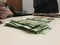 Three different piles of stacked mexican pesos over a white table with documents in the background