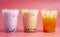 Three Different Types of Boba Tea on a Bright Pink Background