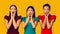 Three Discontented Girls Screaming Standing On Yellow Studio Background, Panorama