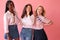 Three diverse beautiful young female friends posing with smile and have a fun on pink background