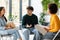 Three diverse enthusiastic friends classmates planning or discussing ideas, communicating in university audience