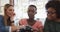 Three diverse female colleagues in discussion sitting looking at images on camera in office