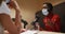 Three diverse female radio hosts wearing face masks talking on microphone for radio podcast