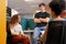 Three diverse young colleagues have an informal meeting, bright open plan office