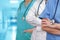 Three Doctors with stethoscope in standing on blurred green background of hospital hall