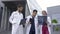 Three doctors, woman in hijab and two men in medical apparel, discussing patient\'s x-ray CT scan