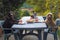 three dogs, Labrador, Cocker spaniel and Boston terrier at a large table eating watermelon in the garden