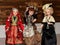 Three dolls in beautiful vintage dresses on a wooden background