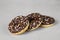 Three donuts covered with chocolate glaze on gray background