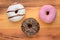 Three doughnuts on a wooden surface, close-up. The view from the top