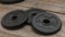 Three dumbbell discs for weight lifting on wooden floor