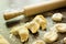 Three dumplings with cherries on the table next to a rolling pin and dough blanks for dumplings