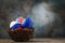 Three Easter eggs in a nest painted in colors of the flags of Russia, America and European Union on a wooden table