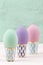 Three Easter eggs of pastel color on retro stands.