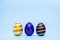Three easter trendy colored classic blue and golden decorated eggs striped pattern on blue. Happy Easter card with copy