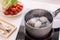 Three eggs boiling in pan of water