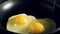 Three eggs are broken in the pan. Closeup
