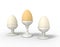 Three eggs in egg cups lined up.