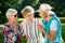 Three elderly female friends gossiping outdoors