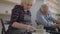 Three elderly people work on a potter's wheel in slow motion