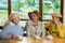 Three elderly women drinking coffee.