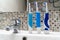 Three electric toothbrushes stand on the washbasin