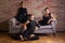 Three elegant latin women dancers in black dresses posing near sofa