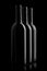 Three elegant wine bottles in black background