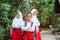 three elementary students standing at the side of country road crossing their hands