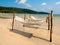 Three empty rope cradle hanging on the wooden poles on sandy beach on the sea, island and blue sky background.