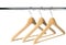 Three empty wooden coat /clothes hangers on a clothes rail